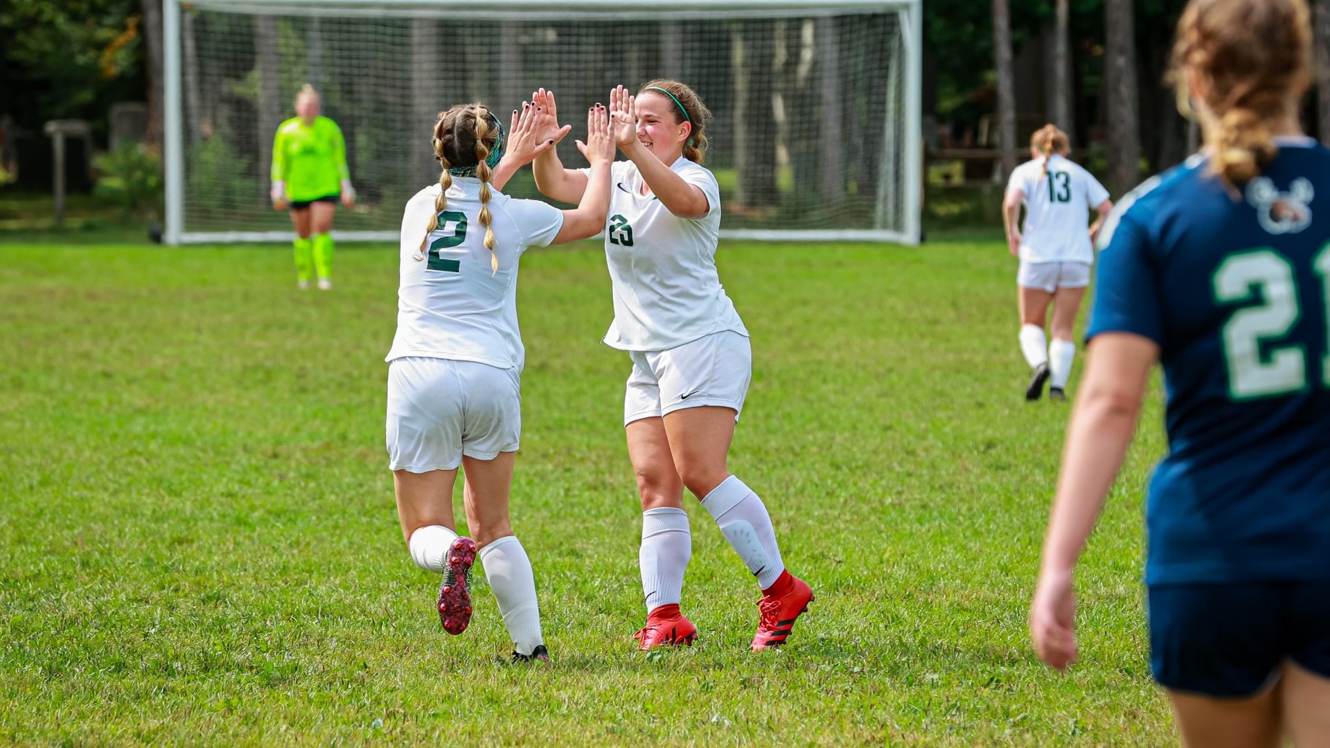Samantha Severing (left #2) celebrates with Haven Bradt (right #25) after a goal (Mercedes Rideout photo). Thumbnail